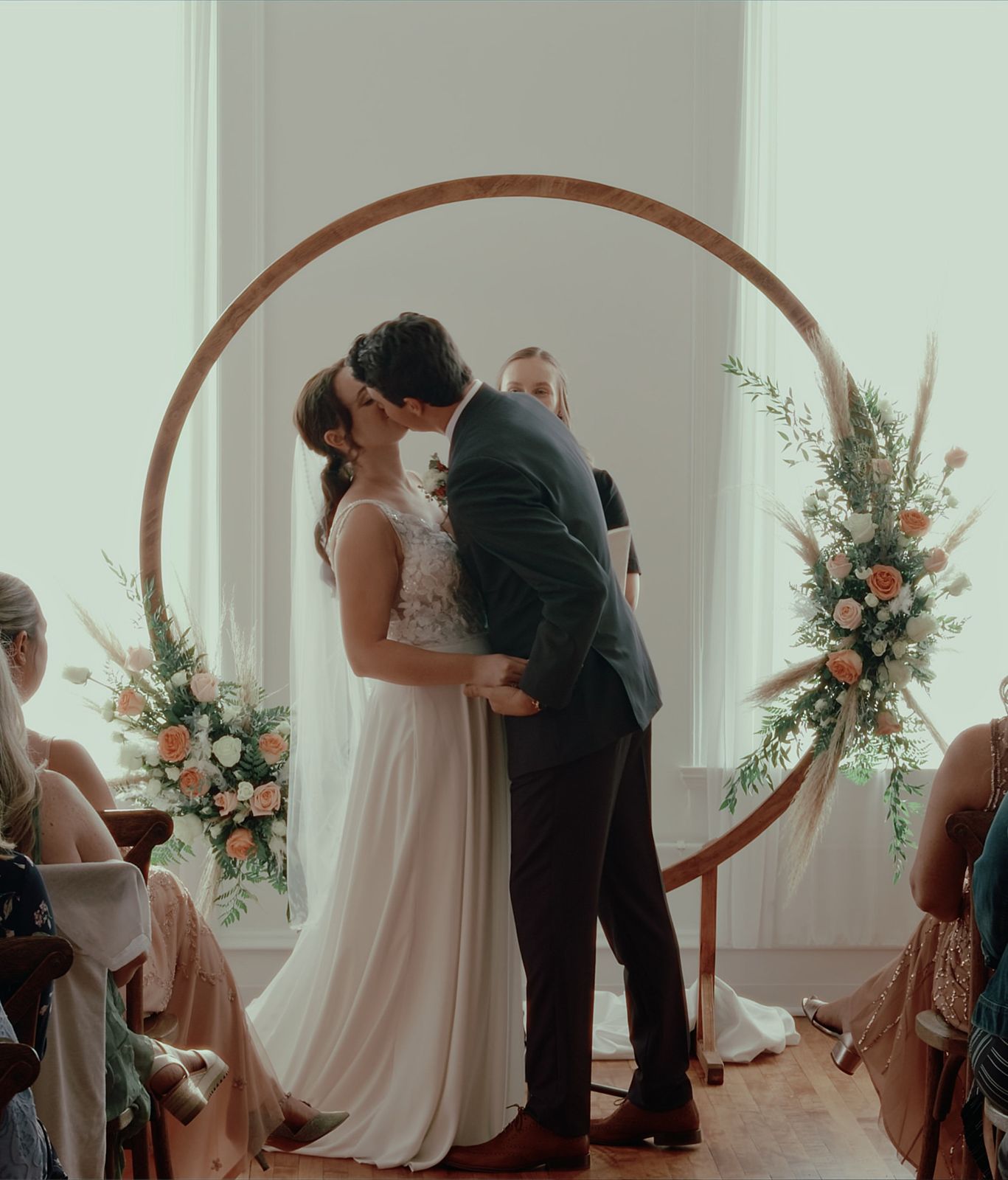 First kiss under a round wooden arch