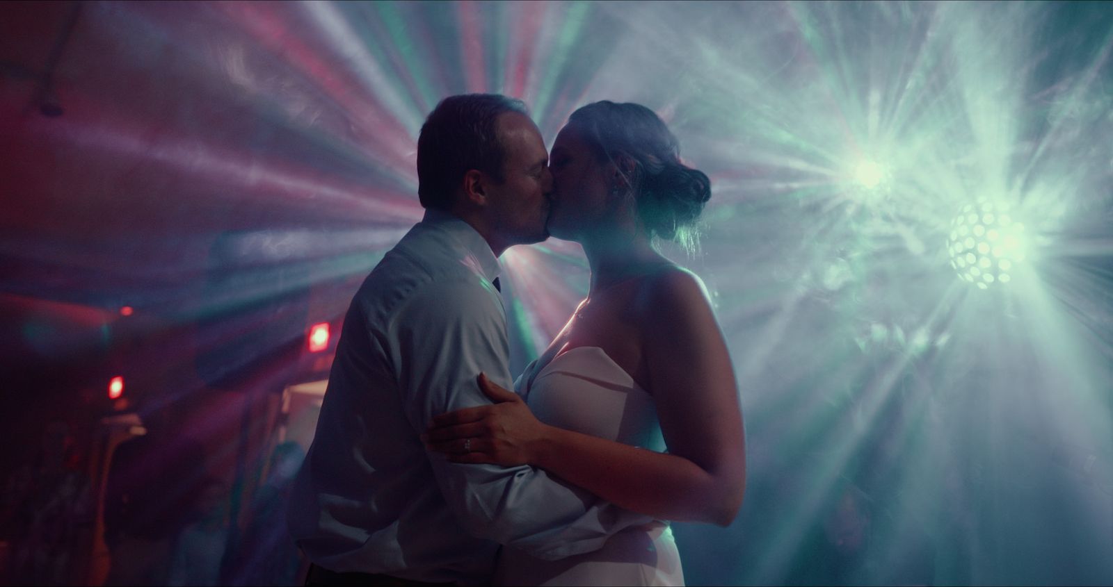 Couple kissing under dance floor lights